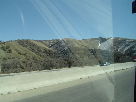 1989 Ford Bronco - View from a vehicle traveling on a highway, with mountains in the background.