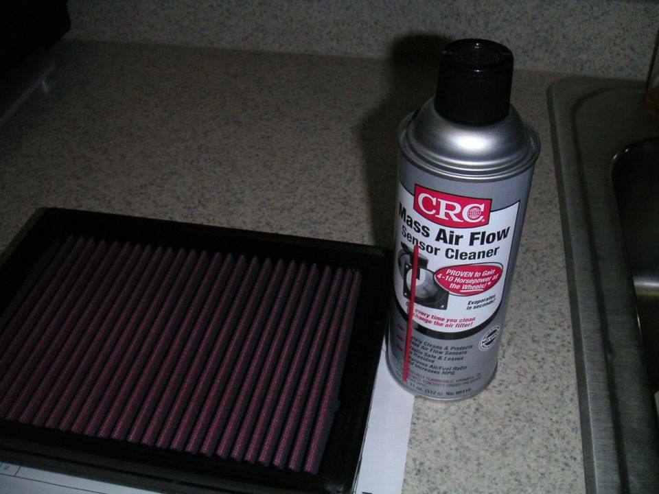 CRC Mass Air Flow Sensor Cleaner can next to a red K&N air filter