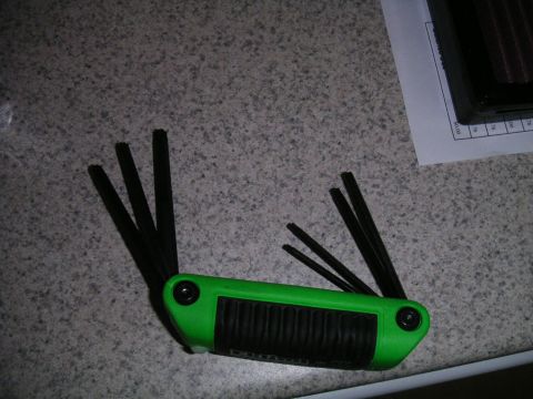 2002 BMW M3 - A green allen wrench set and an air filter are shown on a surface with a document.