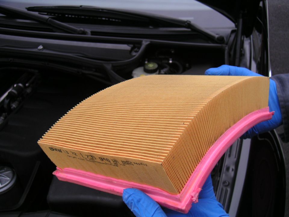 BMW air filter with part number 13721730916 visible, held by gloved hands