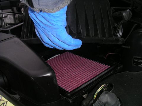 2002 BMW M3 - Gloved hand removes an air filter from a BMW engine bay.