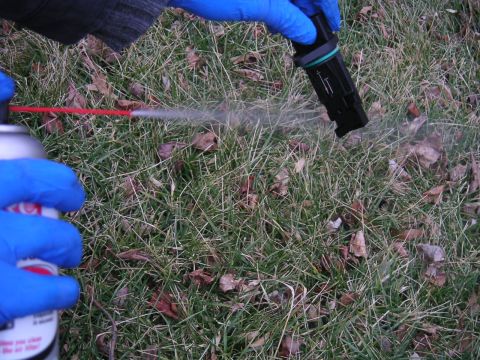 2002 BMW M3 - A mass air flow sensor is cleaned with spray cleaner outdoors.