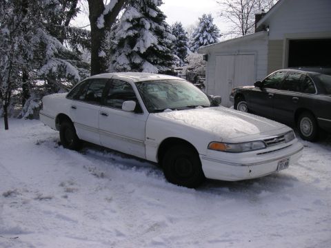 1997 Ford Crown Victoria - White 1997 Ford Crown Victoria sits in a snowy driveway next to a dark sedan.