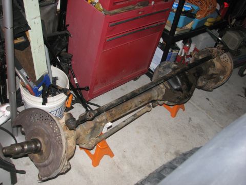 1984 Ford Bronco II - Axle assembly with disc brakes, likely from a truck or SUV, resting on jack stands in a garage.