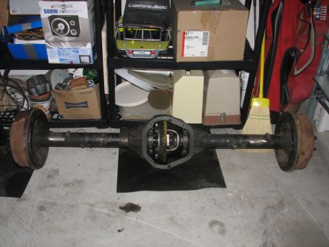 1984 Ford Bronco II - A rear axle assembly is shown with its differential housing open, resting on a black mat.