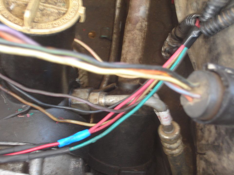 Loose multicolored engine bay wiring with a blue butt splice connector