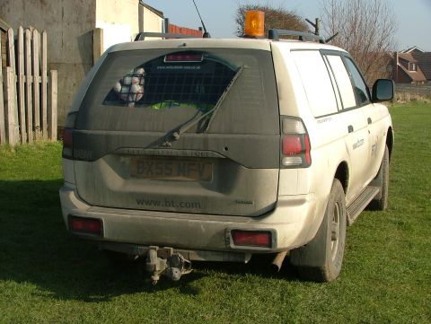 2006 Mitsubishi L200 - Rear view of a white van with a tow hitch and a license plate reading BX55 NFV.