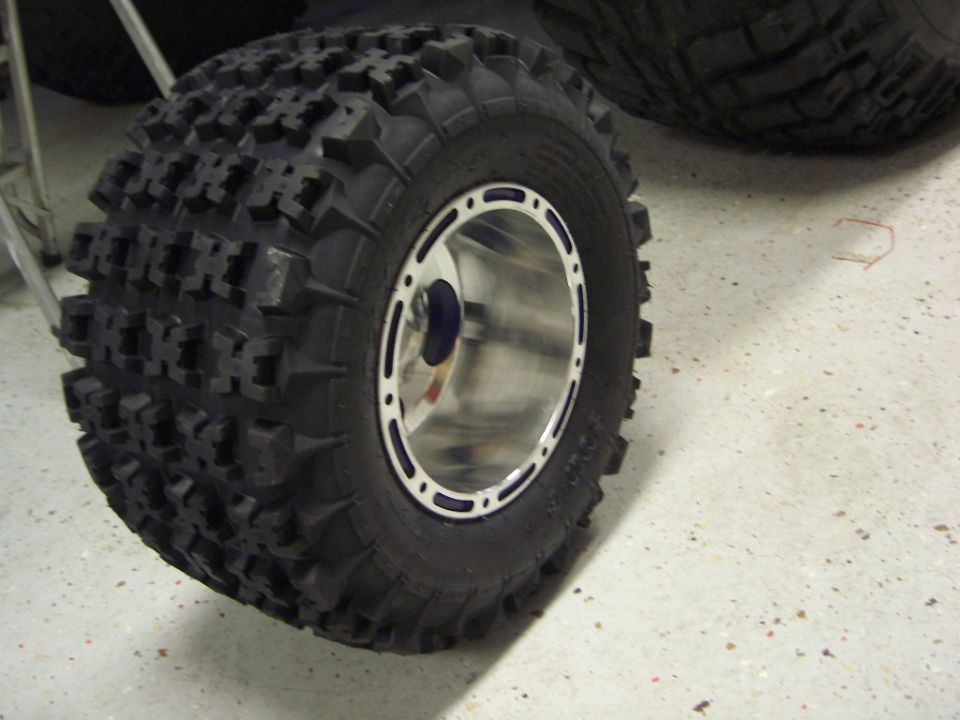 Off-road tire with aggressive tread pattern on a polished metal rim