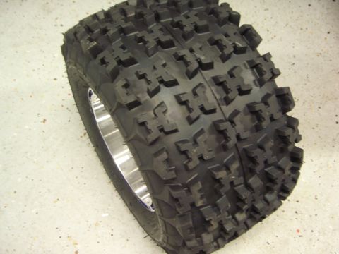 1974 Ford Bronco - This is a close-up view of a knobby tire mounted on a polished metal wheel, likely for an all-terrain vehicle.