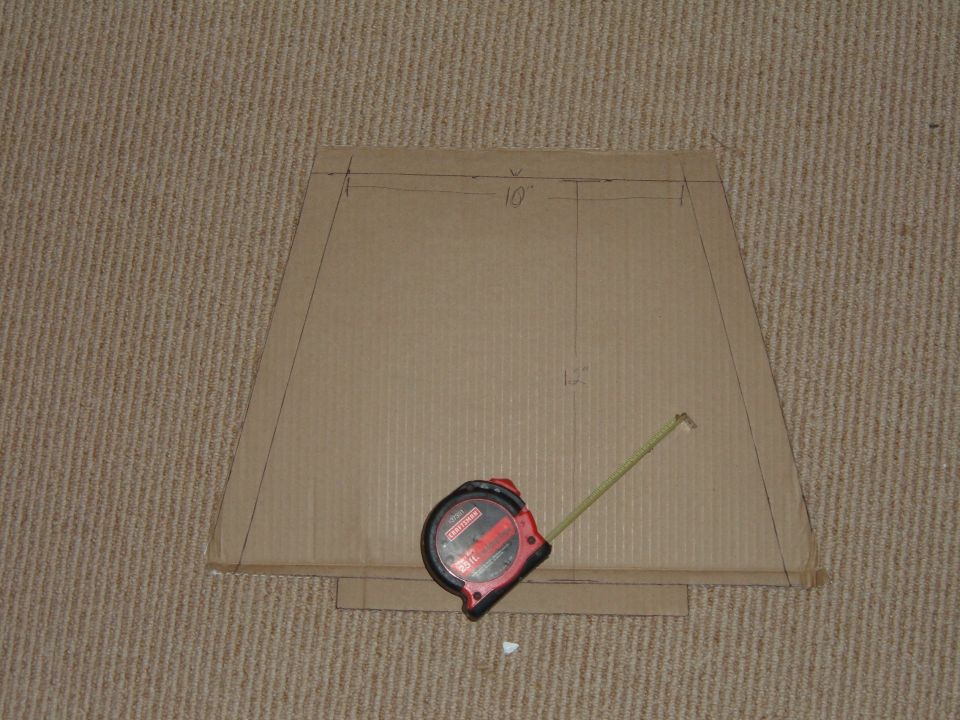 Cardboard rack template marked 10 and 12 inches with a red Craftsman tape measure