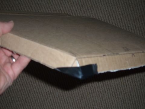 1998 BMW R1100GS ABS - A hand holds a cardboard box with black plastic trim, possibly a motorcycle part.