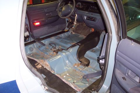 2001 Ford Crown Victoria - Interior of a 2001 Ford Crown Victoria with seats and carpet removed, revealing the floor pan.