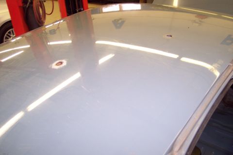 2001 Ford Crown Victoria - Close-up of a car's roof showing two dents, one with visible rust.