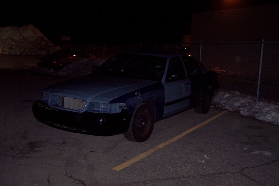 2001 Ford Crown Victoria parked at night, front end partially disassembled