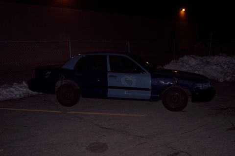 2001 Ford Crown Victoria - A Ford Crown Victoria sits parked at night, its doors painted in contrasting colors.
