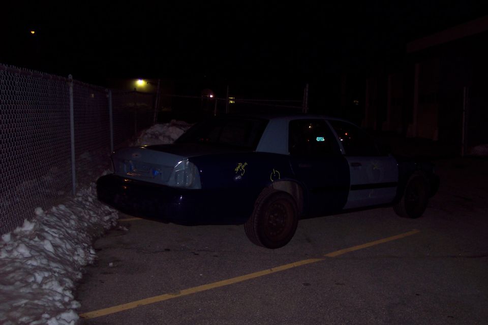 Dark blue and grey 2001 Ford Crown Victoria parked at night, rear quarter view