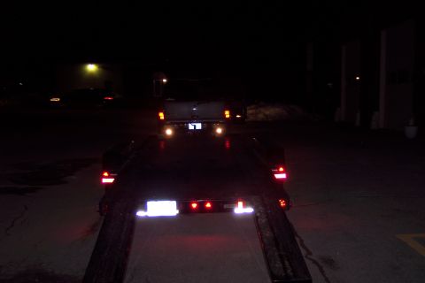 2001 Ford Crown Victoria - Trailer loaded with a vehicle at night, viewed from the rear of the trailer.