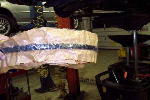 2001 Ford Crown Victoria - A vehicle part is shown wrapped in protective paper and plastic.