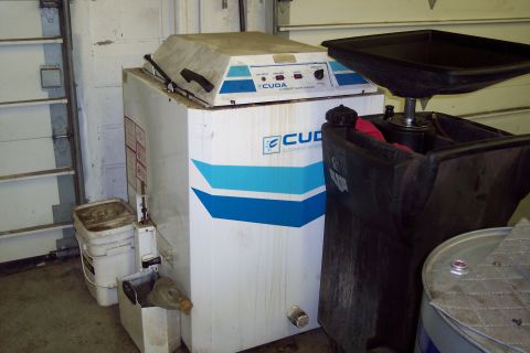 2001 Ford Crown Victoria - A CUDA cleaning system part is shown next to a drain pan and buckets in a garage setting.