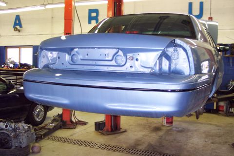 2001 Ford Crown Victoria - Rear view of a blue 2001 Ford Crown Victoria undergoing service on a lift, with taillights removed.
