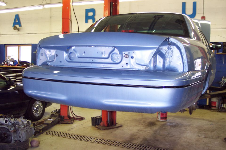 Blue 2001 Ford Crown Victoria rear end on lift, missing taillights
