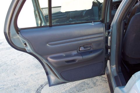 2001 Ford Crown Victoria - Interior view of a 2001 Ford Crown Victoria, showing the rear door panel and seat.