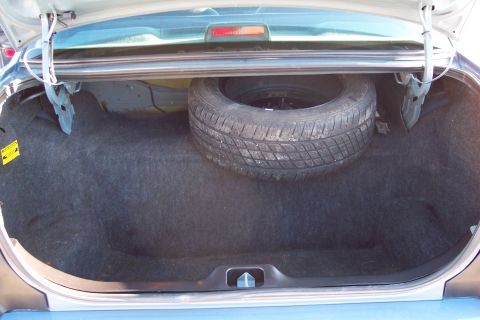 2001 Ford Crown Victoria - The trunk of a 2001 Ford Crown Victoria contains a spare tire and carpeting.