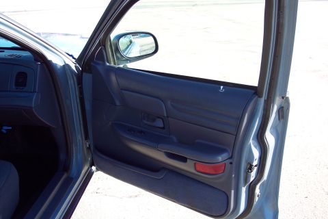2001 Ford Crown Victoria - Interior view of a 2001 Ford Crown Victoria's driver's side door, revealing the dark blue door panel and controls.