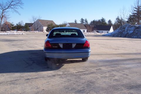 2001 Ford Crown Victoria - Rear view of a blue 2001 Ford Crown Victoria parked in a lot during winter.