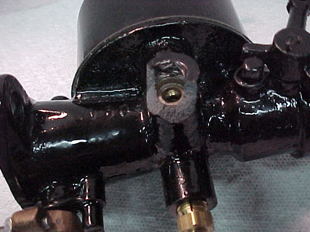 Close-up of a freshly black-painted mechanical assembly with brass fitting