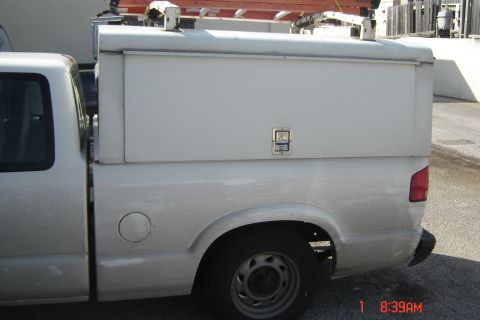 2006 Honda CBR-RR - A white pickup truck is parked outdoors, showing its side profile with a utility cap and ladder rack.