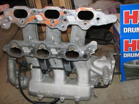 1993 Ford Probe - An aluminum intake manifold is shown with visible gasket residue and attached hoses.