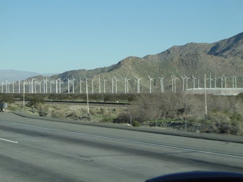 1989 Ford Bronco - A vast field of wind turbines stretches across a landscape with mountains in the background.