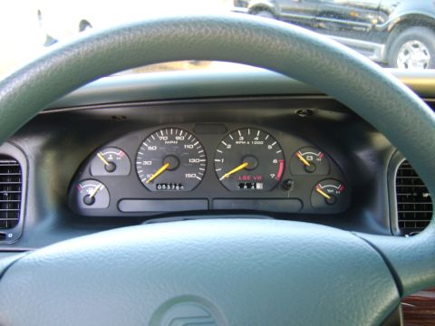 1996 Mercury Grand Marquis - Interior view of dashboard gauges, including the odometer and tachometer, with another vehicle visible through the windshield.