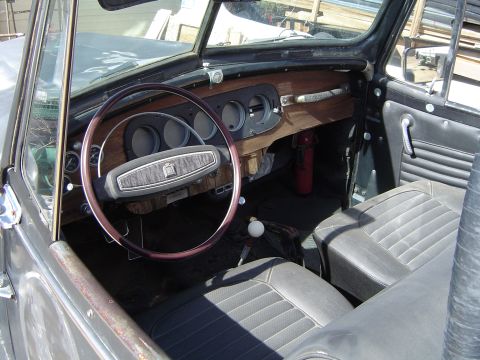 1989 Ford Bronco - The interior of a car shows a wood-grain dashboard and dark seats.