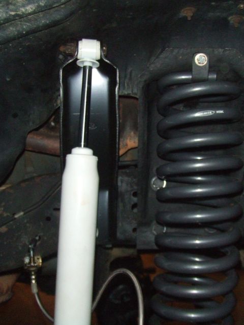 1996 Ford Bronco - The image shows a vehicle's suspension system, focusing on a shock absorber and coil spring.