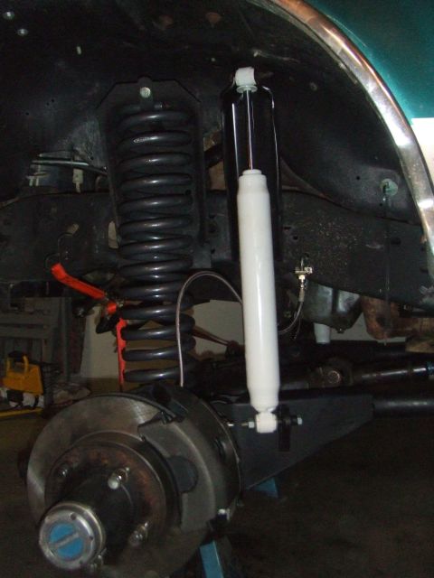 1996 Ford Bronco - Close-up view of a vehicle's front suspension system, showing a coil spring and shock absorber.