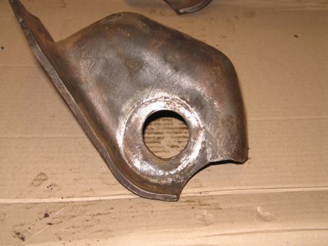 1995 Ford Bronco - Close-up of a heavily rusted metal bracket with a central circular opening.