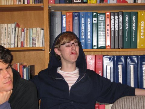 1980 Ford Bronco - Two young men are seated in front of a wall of books, with one wearing a hooded sweatshirt.