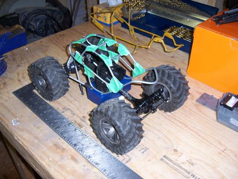 1996 Ford Bronco - A partially assembled remote control rock crawler chassis sits on a wooden workbench next to a ruler and tools.