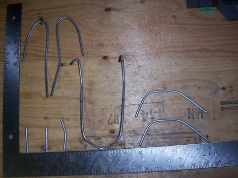 1996 Ford Bronco - Various bent metal tubes are laid out next to rulers on a wooden surface.