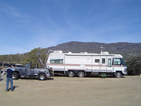 1989 Ford Bronco - RV and Jeep CJ-7 parked outdoors with a mountainous background.