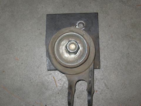 1994 Ford Bronco - This image shows a close-up of a metal component, possibly a bracket or mount, with a visible bolt and nut assembly.