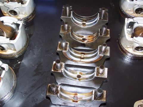 1974 Ford F-100 - Several engine crankshaft bearings and pistons are visible in this close-up shot.