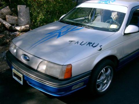 1986 Ford Taurus - This 1986 Ford Taurus features a custom blue stripe design on its hood.