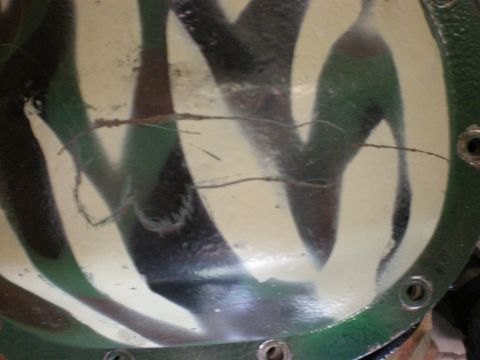1993 Ford Bronco - Close-up of a differential cover with a camouflage paint job and signs of wear.