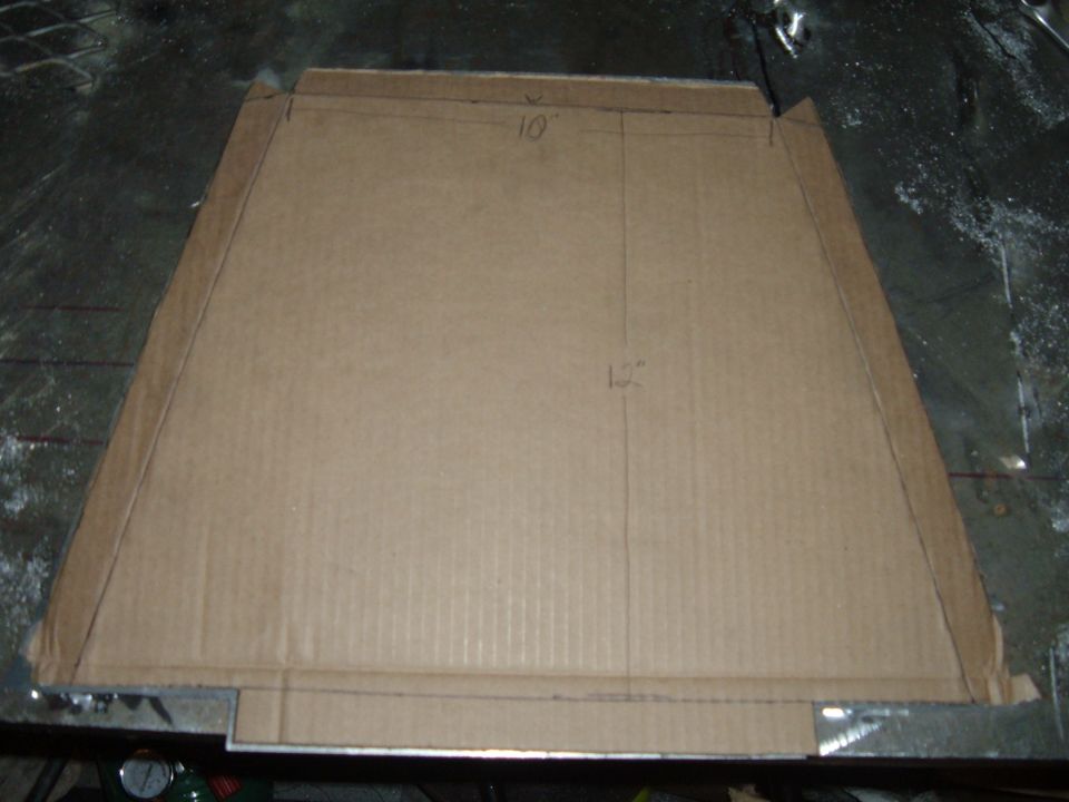 Cardboard fabrication template marked 10 inches and 12 inches on a workbench