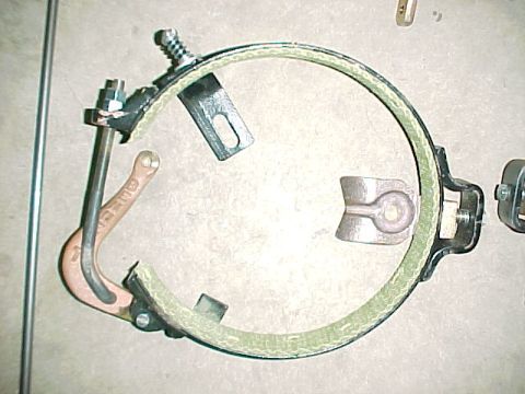 1915 Ford Model T - A brake band assembly with visible metal components and a textured lining is laid out on a surface.