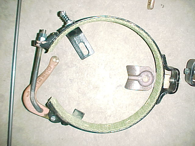 Brake band assembly with green lining and metal clamps, on a textured surface