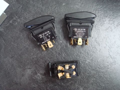 1996 Ford Bronco - Close-up view of three black automotive rocker switches on a dark textured surface.